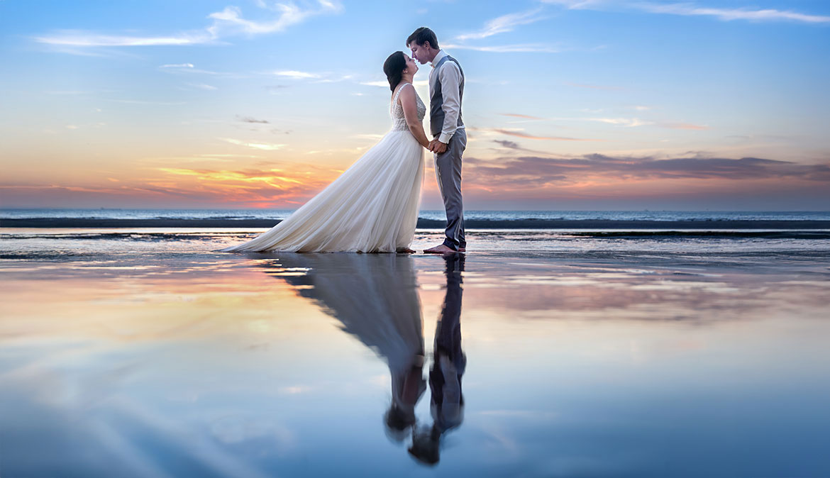 Image de mariés à la mer au coucher du soleil, reflets originales